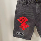 MIXED EMOTION Multi‑Patch Gothic Logo Black Denim Jorts