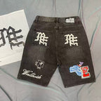 MIXED EMOTION Multi‑Patch Gothic Logo Black Denim Jorts