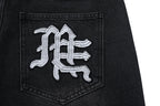 MIXED EMOTION Multi‑Patch Gothic Logo Black Denim Jorts