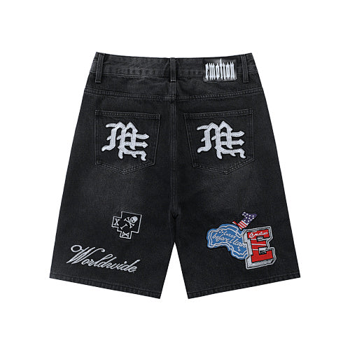 MIXED EMOTION Multi‑Patch Gothic Logo Black Denim Jorts